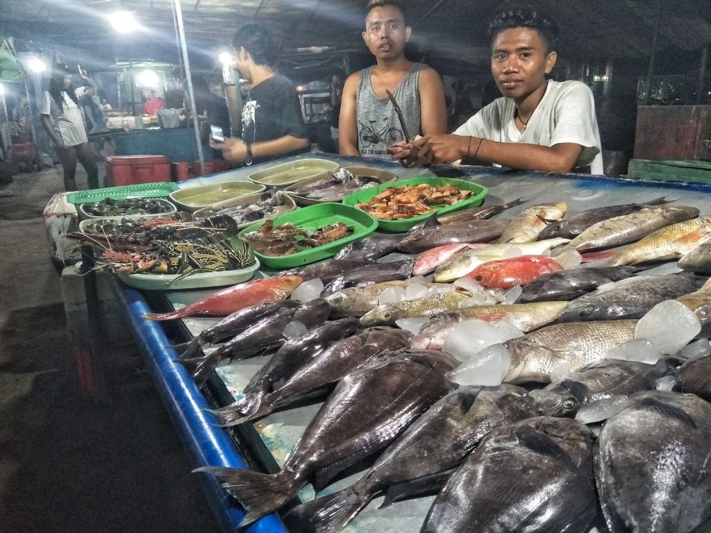 Indonesiani che vendono il pesce al Night Market