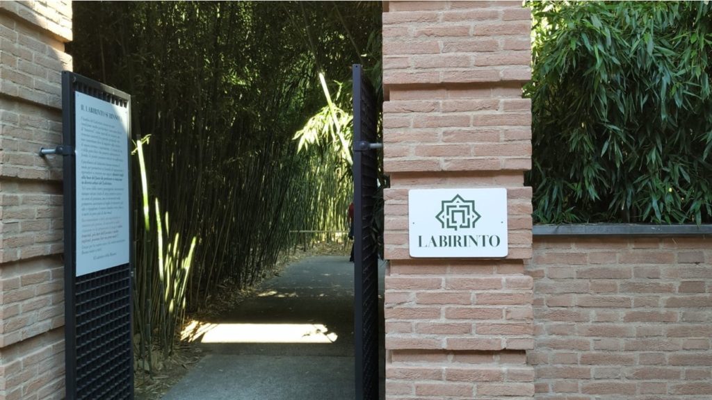 Ingresso in mattoni rossi di un labirinto formato da canne di bambù